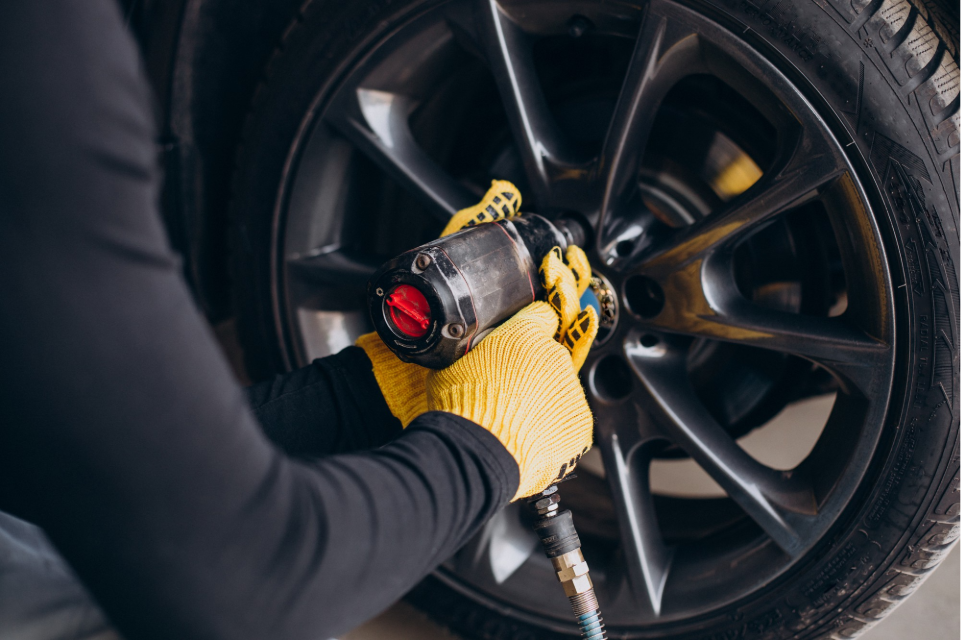Car mechanic rotating wheels in car