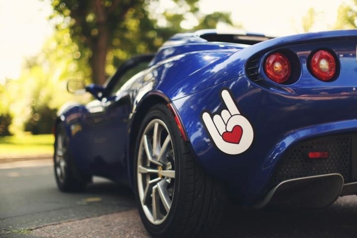 Close-up of a blue sports car with a sticker at its rear