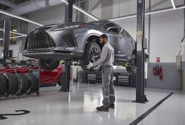 A mechanic using a gauge to check tyre pressure.