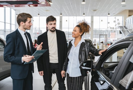 Man in Blue Business Suit Talking to Woman Touching the Car