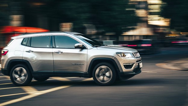 Silver car crossing a road intersection