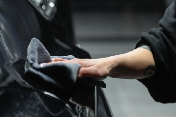 A Person Wiping a Car with a Cleaning Cloth