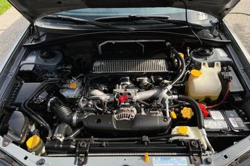 A car engine with visible components under the open hood.