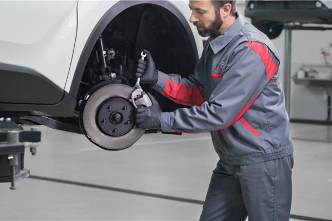 Toyota mechanic working on car brakes