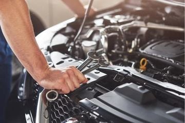 A car service worker repairing vehicle.
