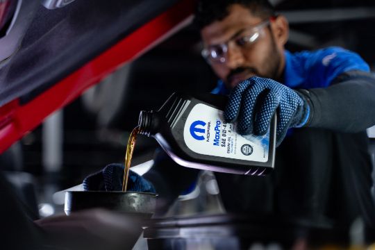 Mechanic checking car engine oil