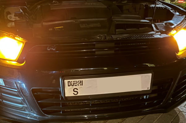 : A used car with the hood open exposing the engine during car inspection.