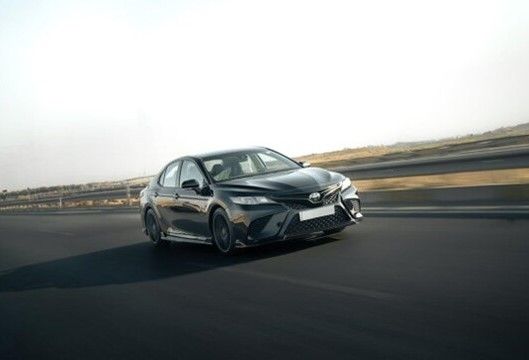A sleek Toyota Camry in motion on a highway.