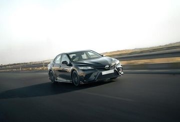 A sleek Toyota Camry in motion on a highway.