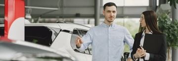 شخصان أنيقان داخل صالة عرض سيارات.
