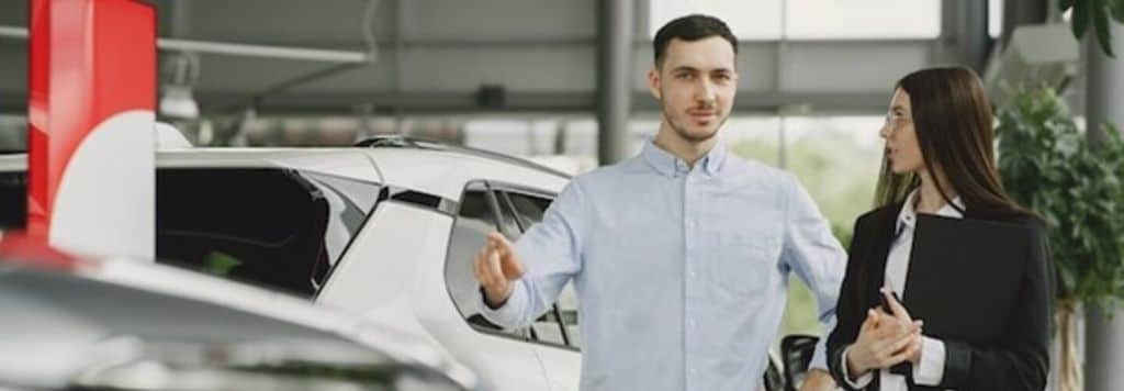 شخصان أنيقان داخل صالة عرض سيارات.