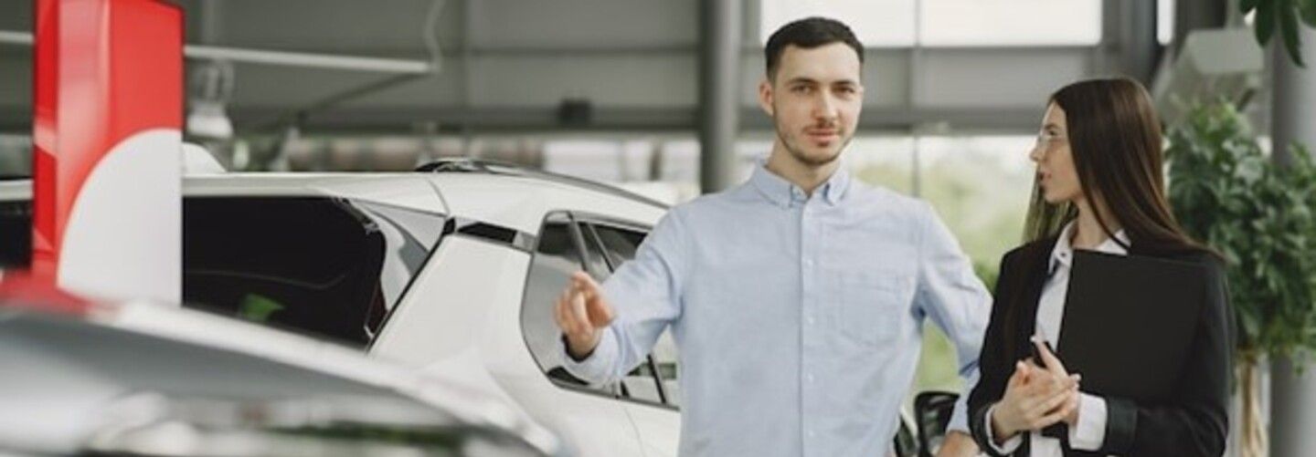 شخصان أنيقان داخل صالة عرض سيارات.