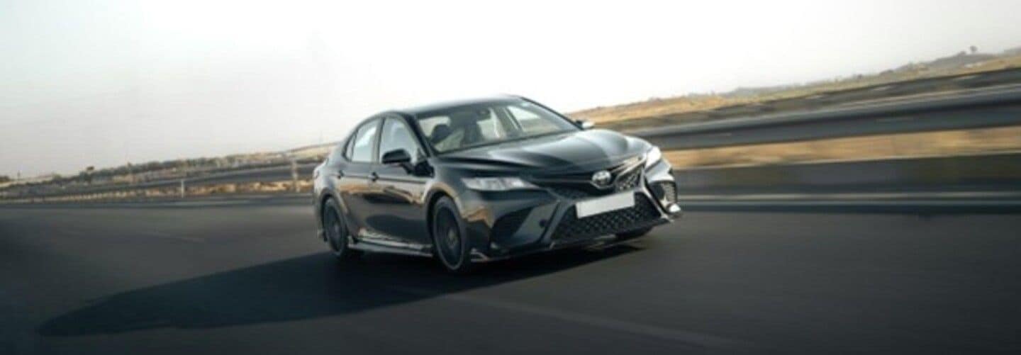 A sleek Toyota Camry in motion on a highway.