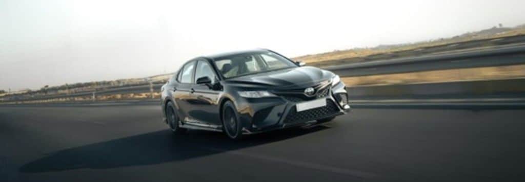 A sleek Toyota Camry in motion on a highway.
