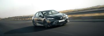 A sleek Toyota Camry in motion on a highway.