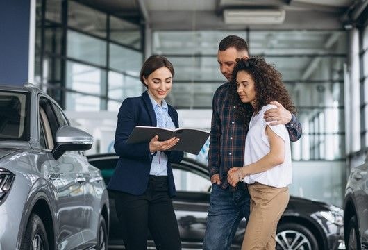 مندوب مبيعات في صالة عرض مع العملاء