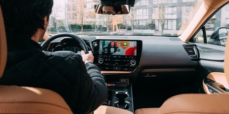 A man driving a car featuring the infotainment system