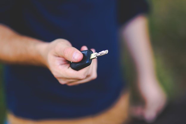A hand holding a car key.
