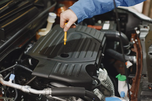 Mechanic checking car engine oil